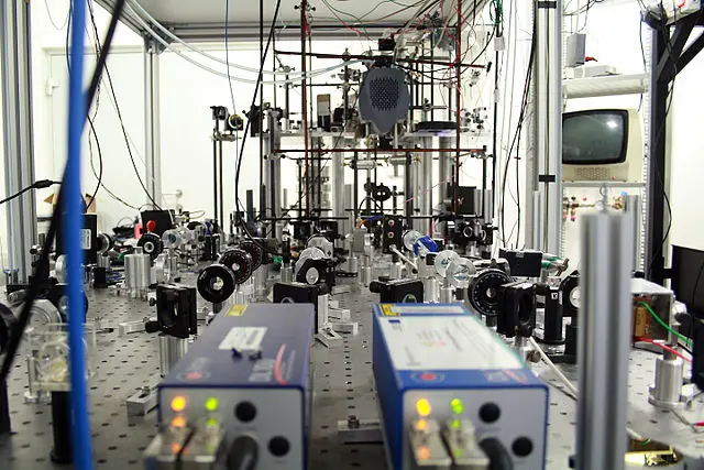 Part of the experimental setup for cooling (slowing) and trapping of rubidium atoms. Two diode lasers with Littrow resonators are seen in the foreground. In the next part of the optical table there are components used to control frequency, intensity and polarization of the laser beams (lenses, mirrors, waveplates, acousto-optic modulators, diaphragms, polarizers and others). In the background there is a vacuum setup, where atoms are trapped.