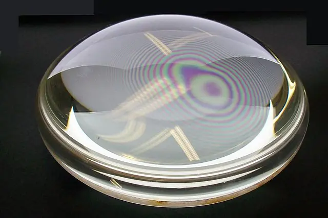 "Newton's rings" interference fringes between 2 plano convex lenses, placed together with their plane surfaces in contact. The rings are created by interference between the light reflected off the two surfaces, caused by a slight gap between them, showing that these surfaces are not precisely plane but are slightly convex.
