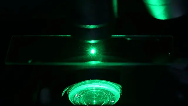 Raman microscope during measurements. Droplet of ionic liquid was placed on a glass plate and Raman spectrum was measured with green laser.